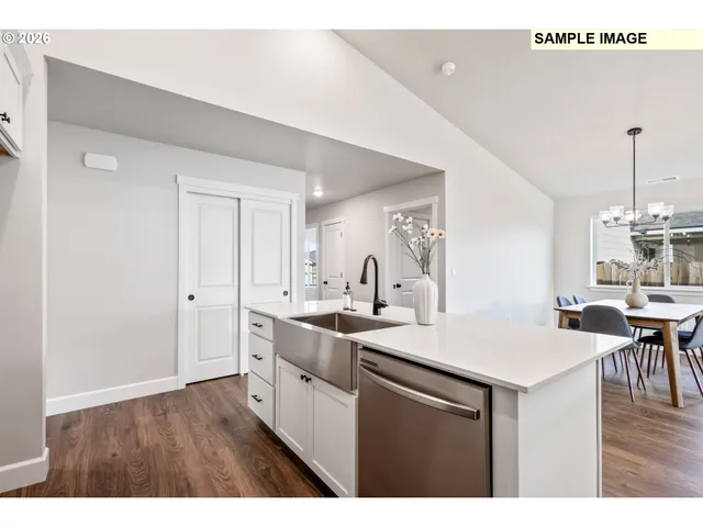 a kitchen with a sink cabinets and wooden floor