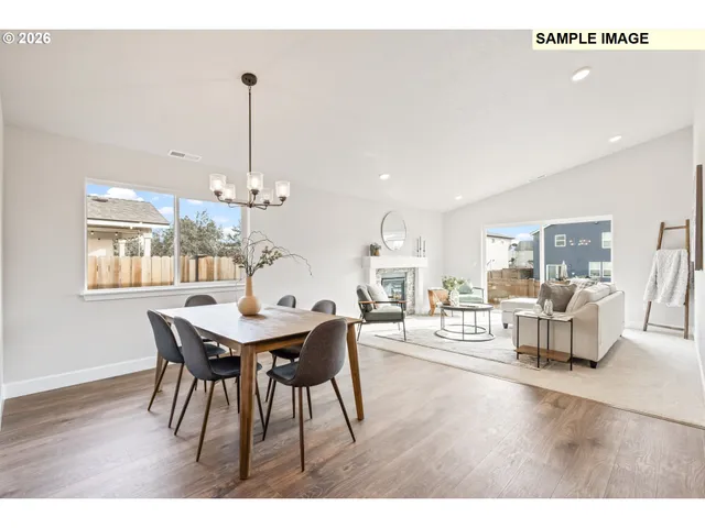 a view of a dining room and livingroom with furniture wooden floor a chandelier