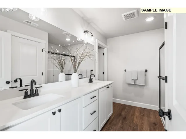 a bathroom with a double vanity sink mirror and shower