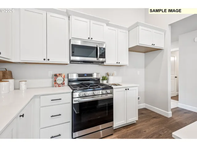 a kitchen with stainless steel appliances granite countertop a stove a microwave and a refrigerator