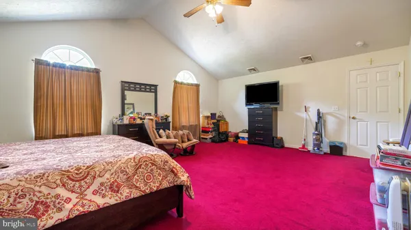 a bed room with a bed mirror and a flat tv screen