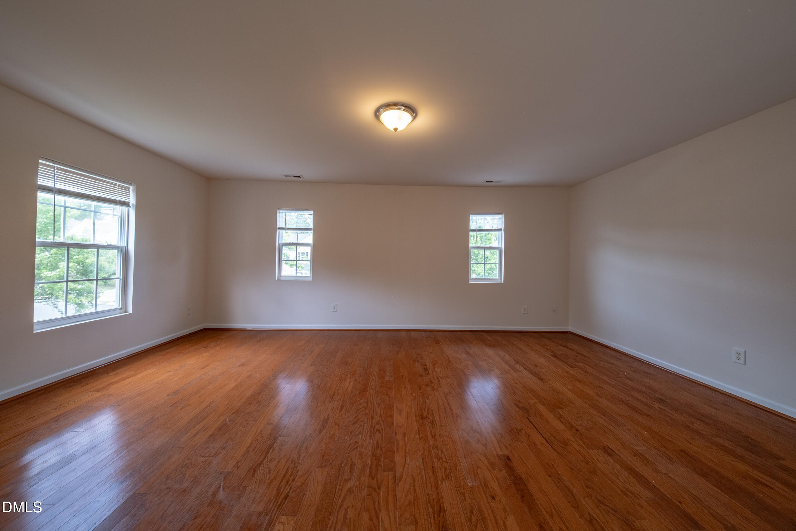 719 Obsidian Way Durham, NC 27703 - Photo 19 of 41 an empty room with wooden floor and windows