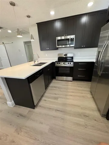 a kitchen with stainless steel appliances kitchen island granite countertop a refrigerator and a stove