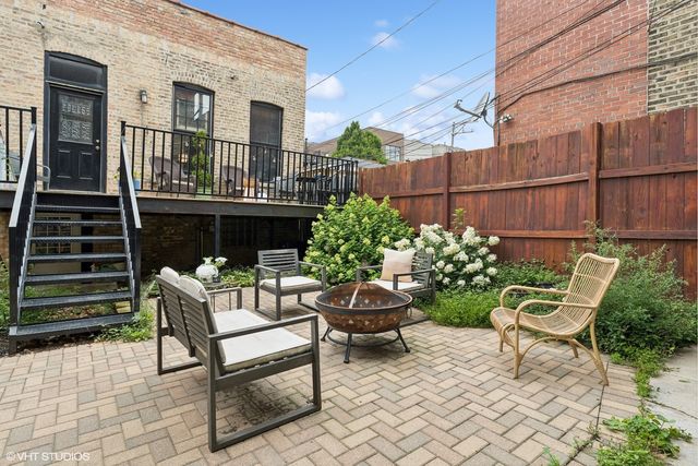 a view of a chairs and table in the back yard of the house