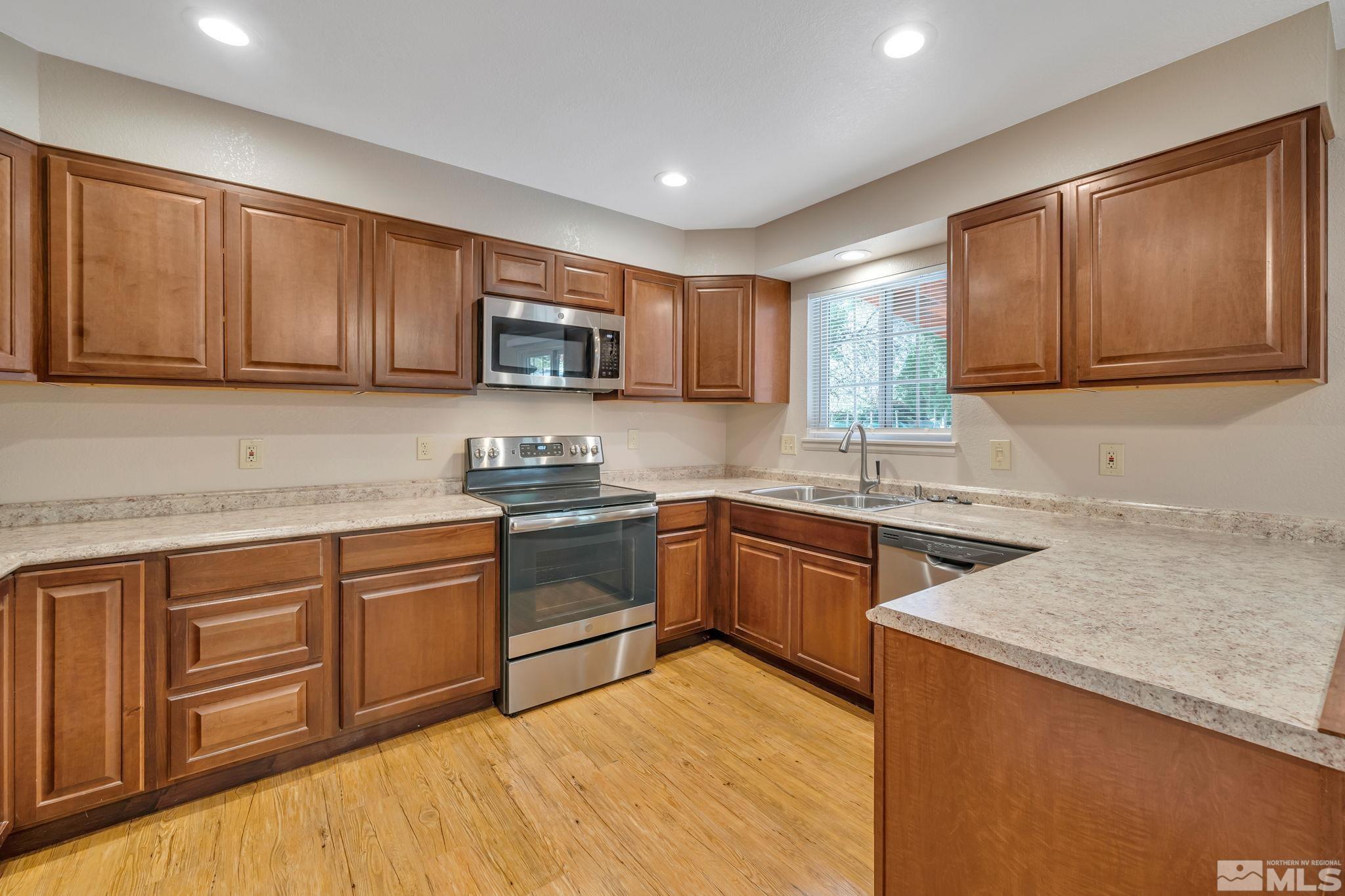 3240 Kings Row Reno, NV 89503 - Photo 11 of 31 a kitchen with stainless steel appliances granite countertop wooden cabinets a stove top oven a sink and dishwasher