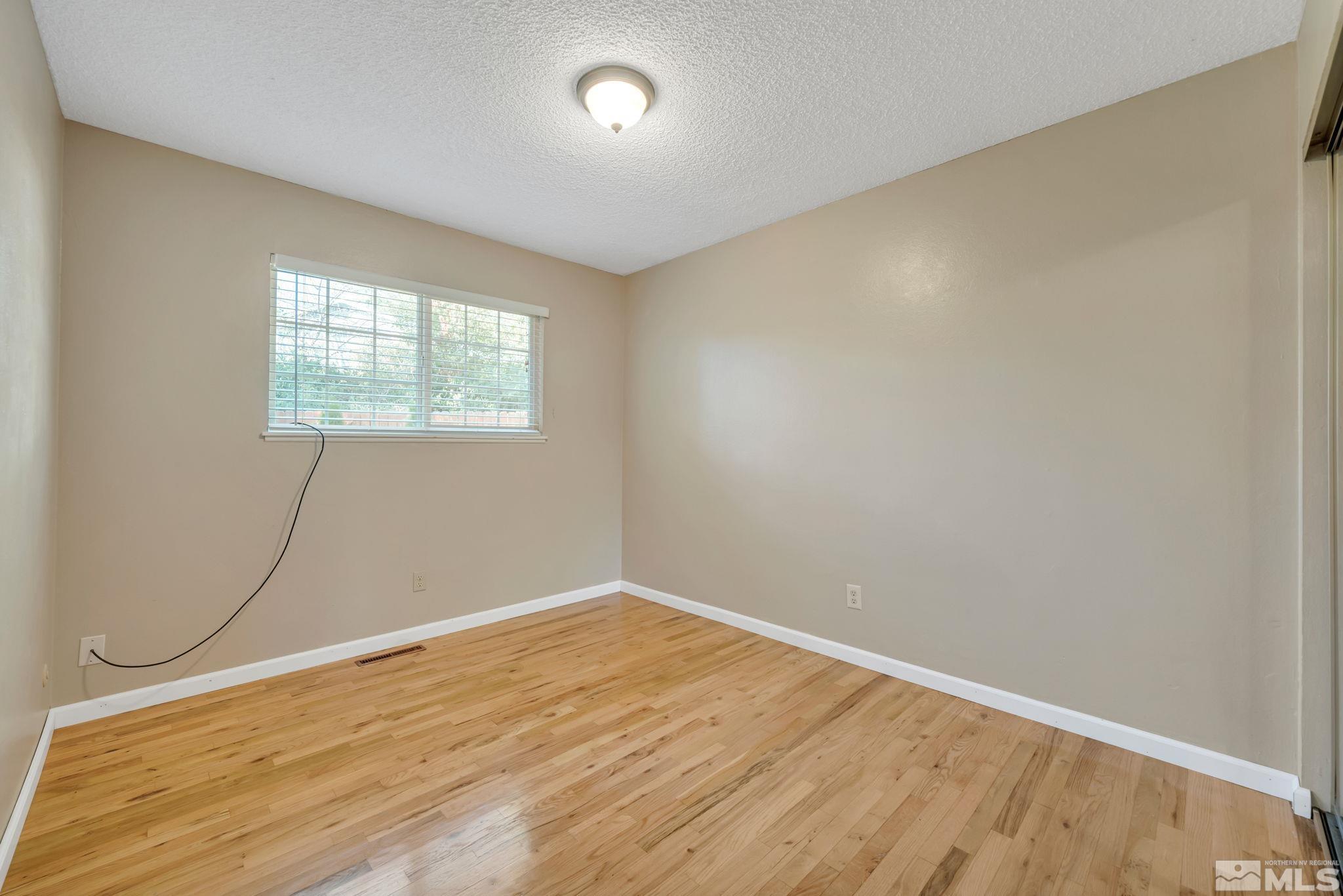 3240 Kings Row Reno, NV 89503 - Photo 22 of 31 an empty room with wooden floor and windows