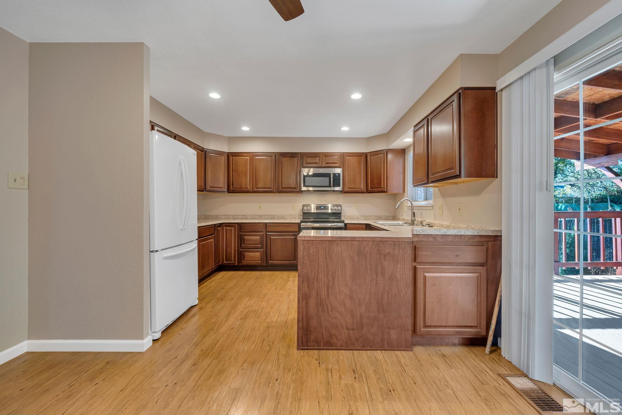 3240 Kings Row Reno, NV 89503 - Photo 7 of 31 a kitchen with granite countertop a refrigerator and a sink
