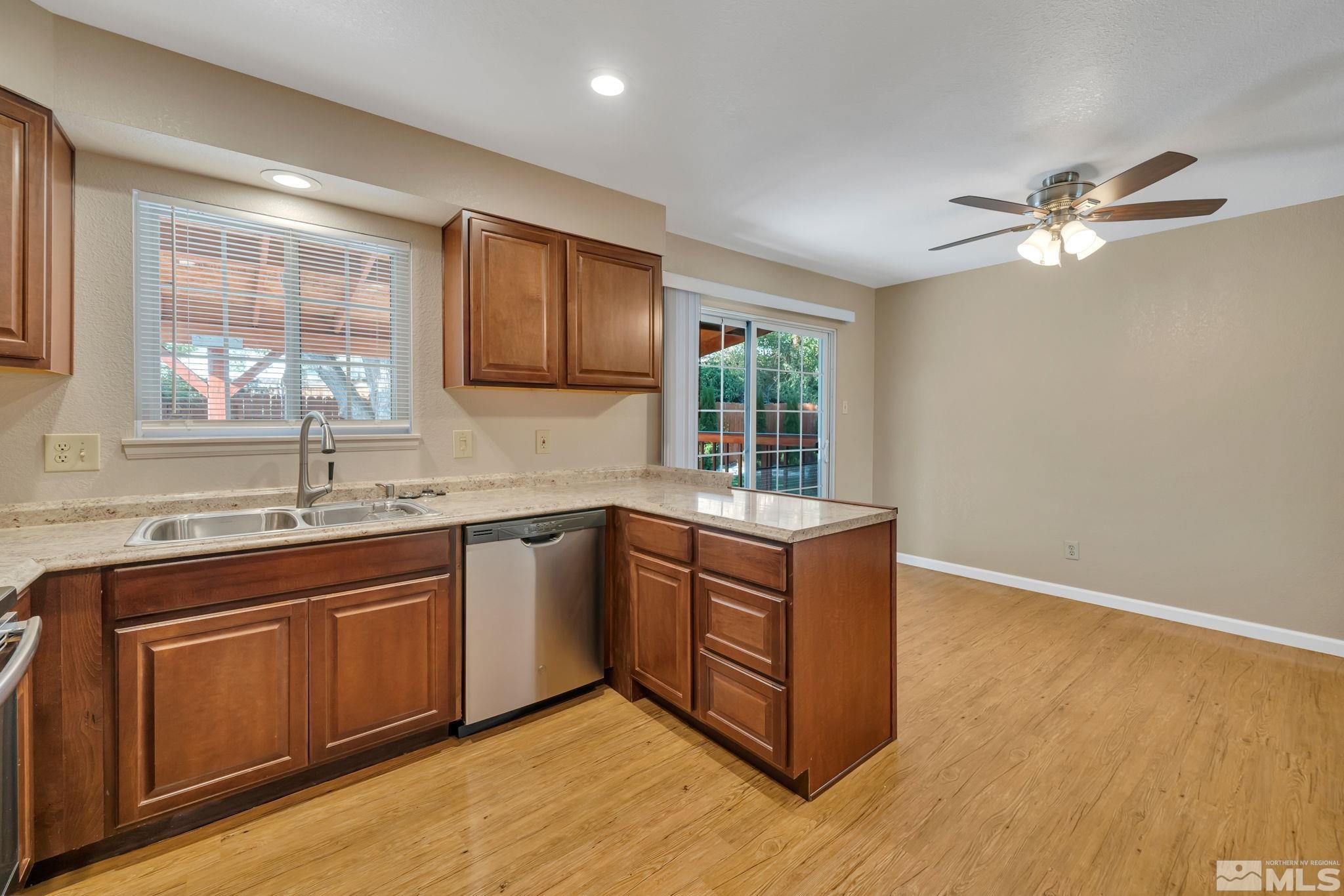 3240 Kings Row Reno, NV 89503 - Photo 8 of 31 a kitchen with stainless steel appliances granite countertop a sink a stove a refrigerator cabinets and wooden floor