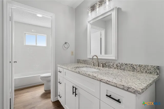 a bathroom with a granite countertop sink and a mirror