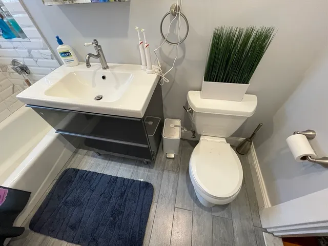 a bathroom with a toilet sink and mirror
