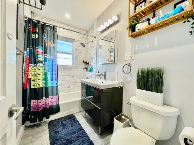 a bathroom with a sink mirror vanity and toilet