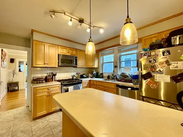 a kitchen with stainless steel appliances granite countertop a sink a stove and a refrigerator