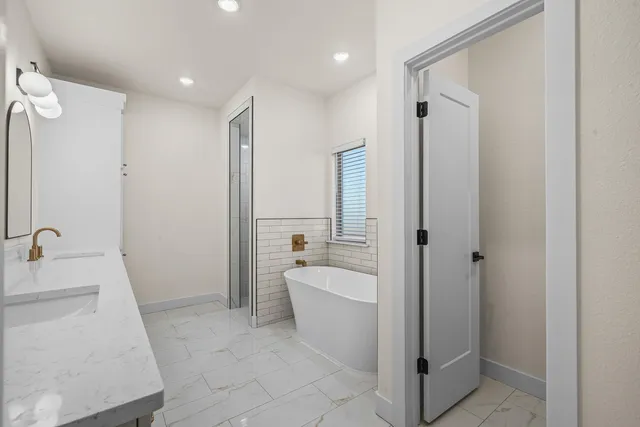 a spacious bathroom with a tub shower and sink