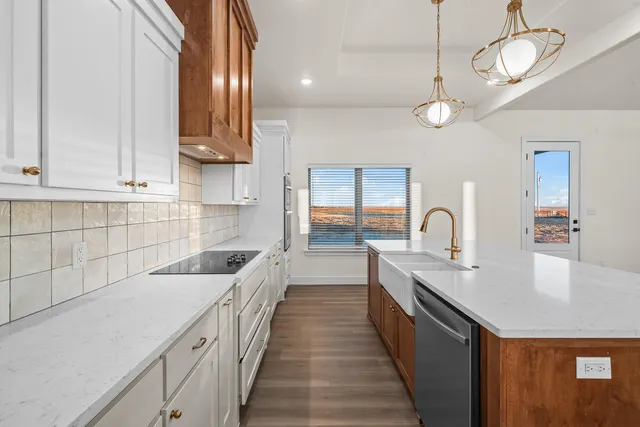 a kitchen with granite countertop a sink a counter space cabinets and stainless steel appliances