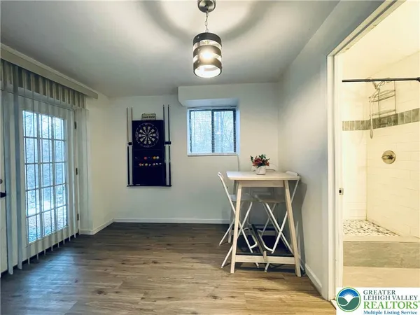 a view of a livingroom with wooden floor windows and a chandelier