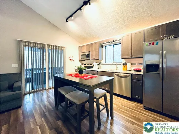 a kitchen with a table chairs refrigerator and cabinets