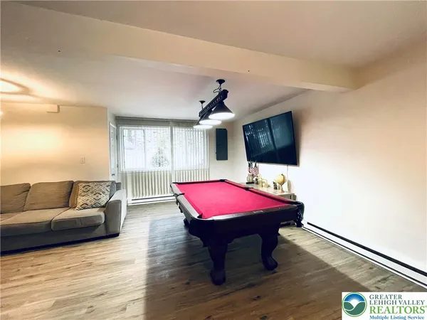 a living room with furniture a flat screen tv and a wooden floor