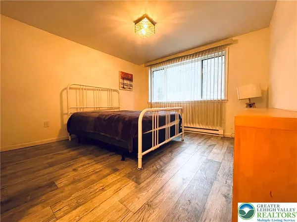 a view of a bedroom with a bed and wooden floor