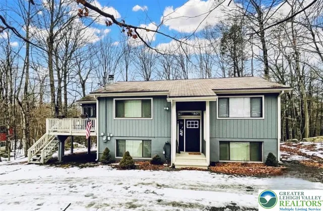 a view of a house with a yard covered with snow in the road