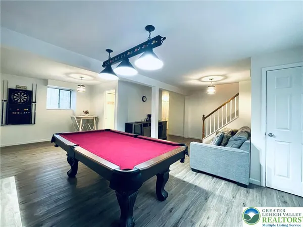 a living room with a table table and a pool table