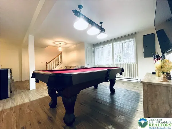 a room with furniture pool table and flat screen tv