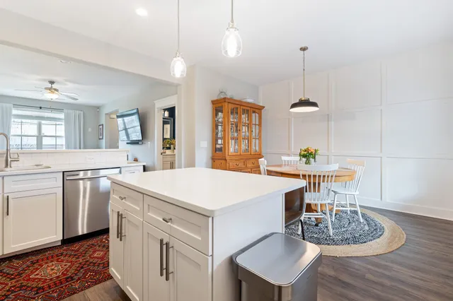a large kitchen with sink a refrigerator dining table and chairs