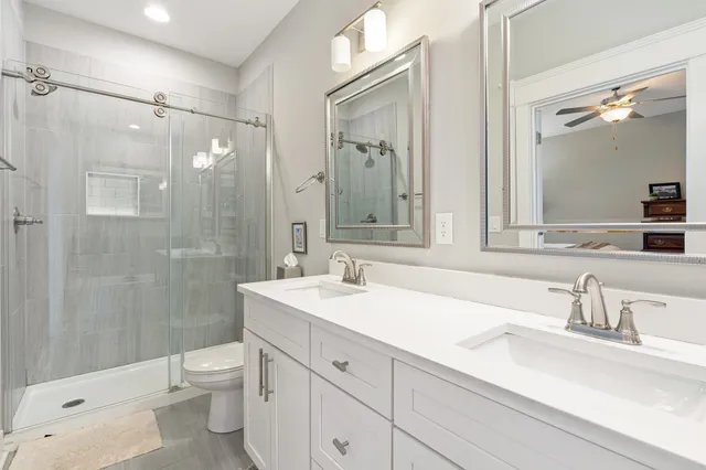 a bathroom with a sink a toilet and shower