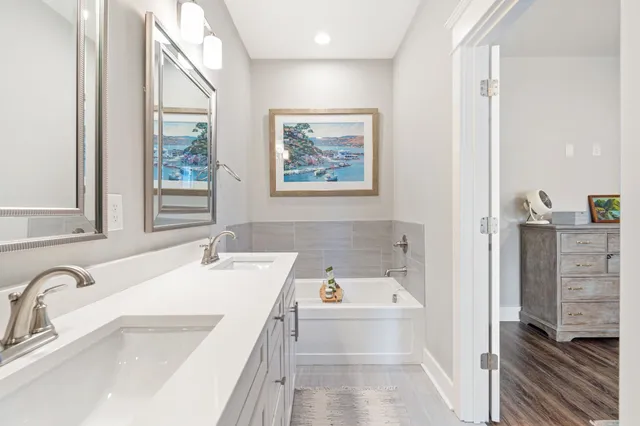 a bathroom with a tub sink and mirror
