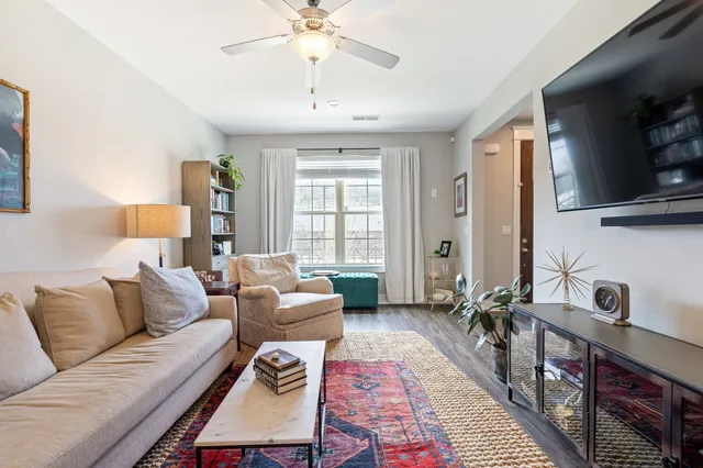 a living room with furniture a flat screen tv and a window