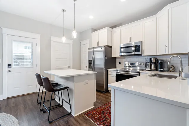a kitchen with a sink a microwave a refrigerator and cabinets
