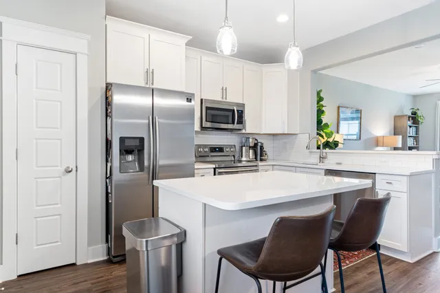 a kitchen with stainless steel appliances a refrigerator sink and stove