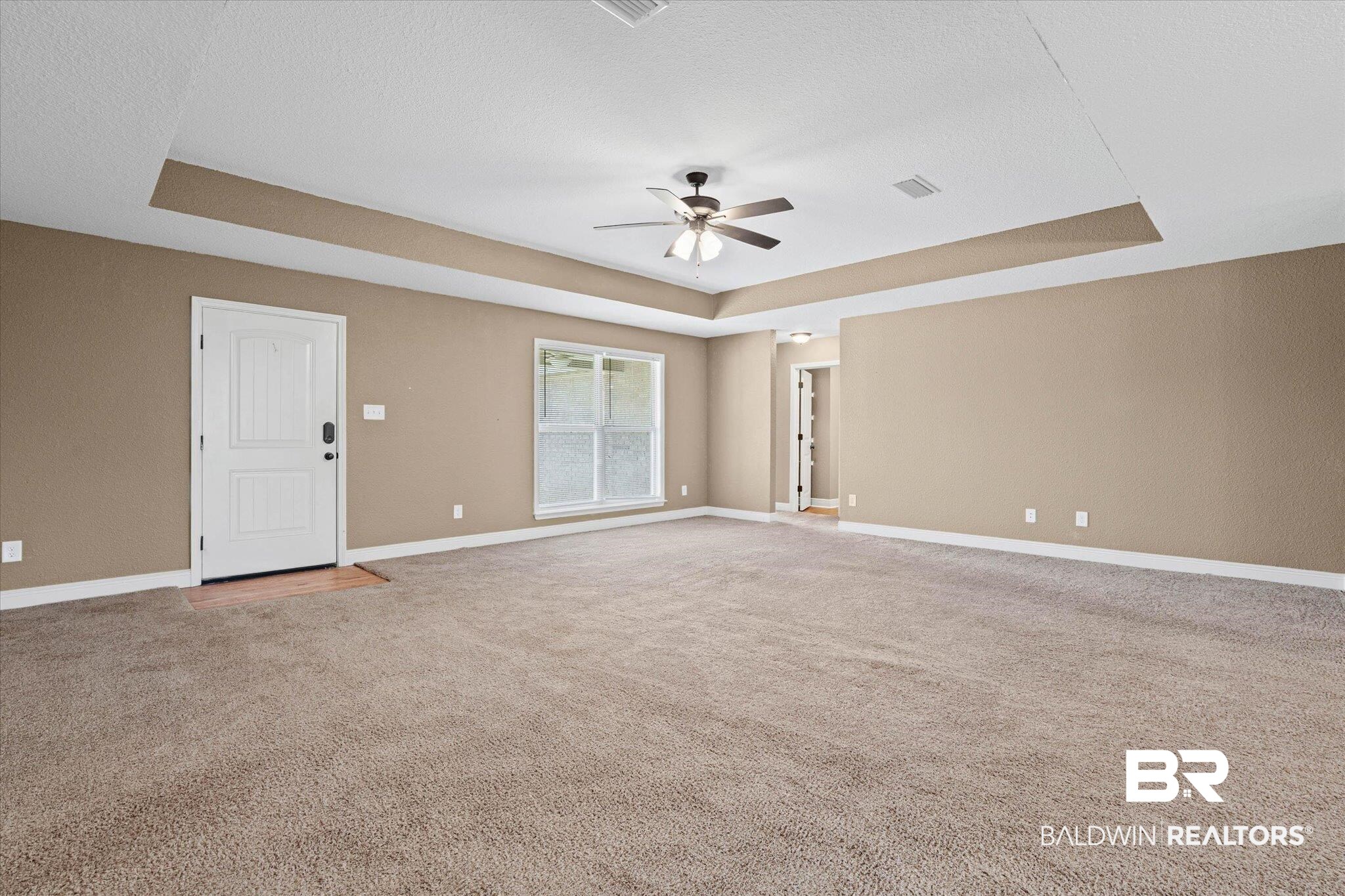 101 Washington Boulevard Foley, AL 36535 - Photo 5 of 32 Empty room with a raised ceiling, a ceiling fan, light carpet, and a textured ceiling