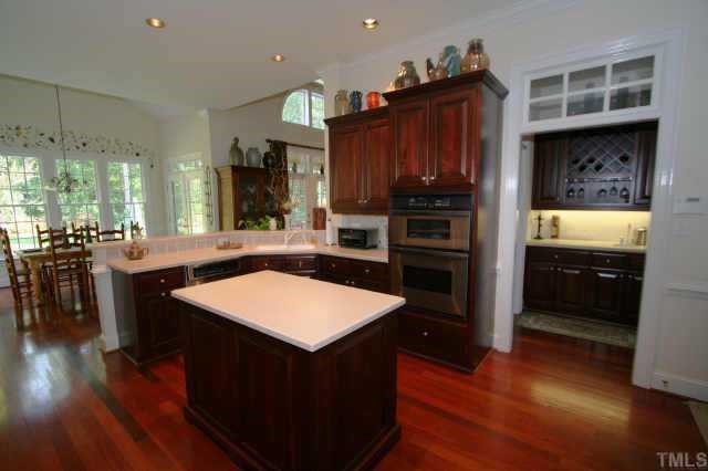 7125 Trenton Ridge Court Raleigh, NC 27613 - Photo 4 of 10 a kitchen with stainless steel appliances granite countertop a stove a refrigerator a sink and a oven with wooden floor