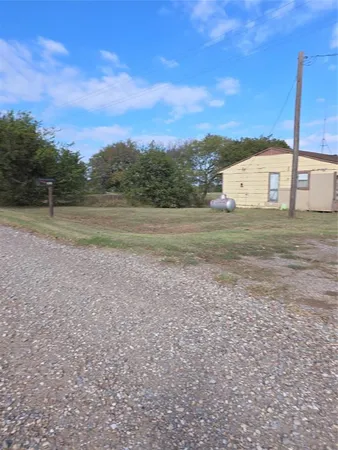 a view of a dry yard with a house
