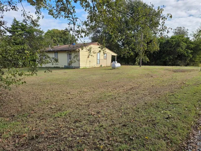 a view of a house with a yard and tree
