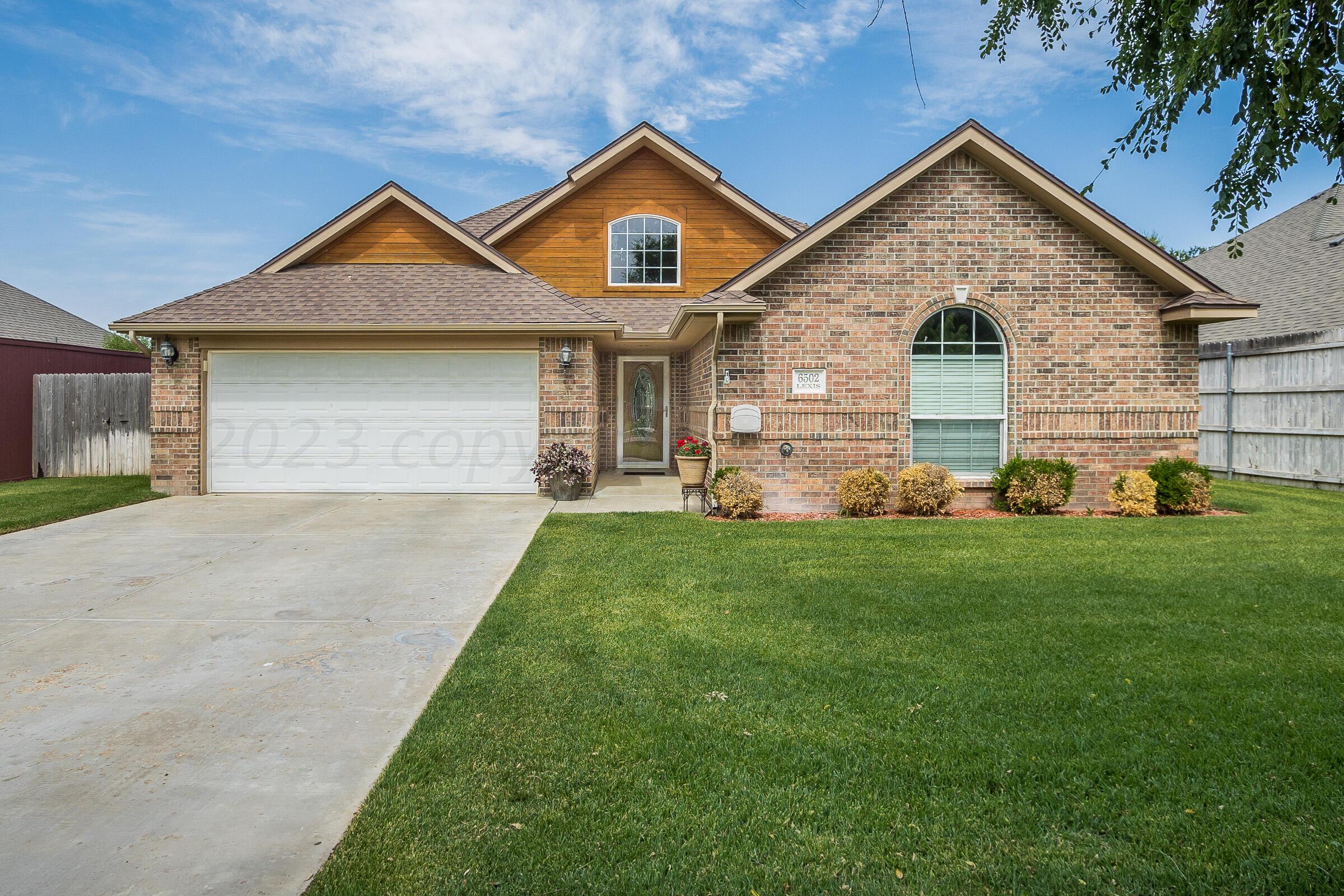 6502 Lexis Street Amarillo, TX 79119 - Photo 1 of 27 a front view of a house with a yard and garage
