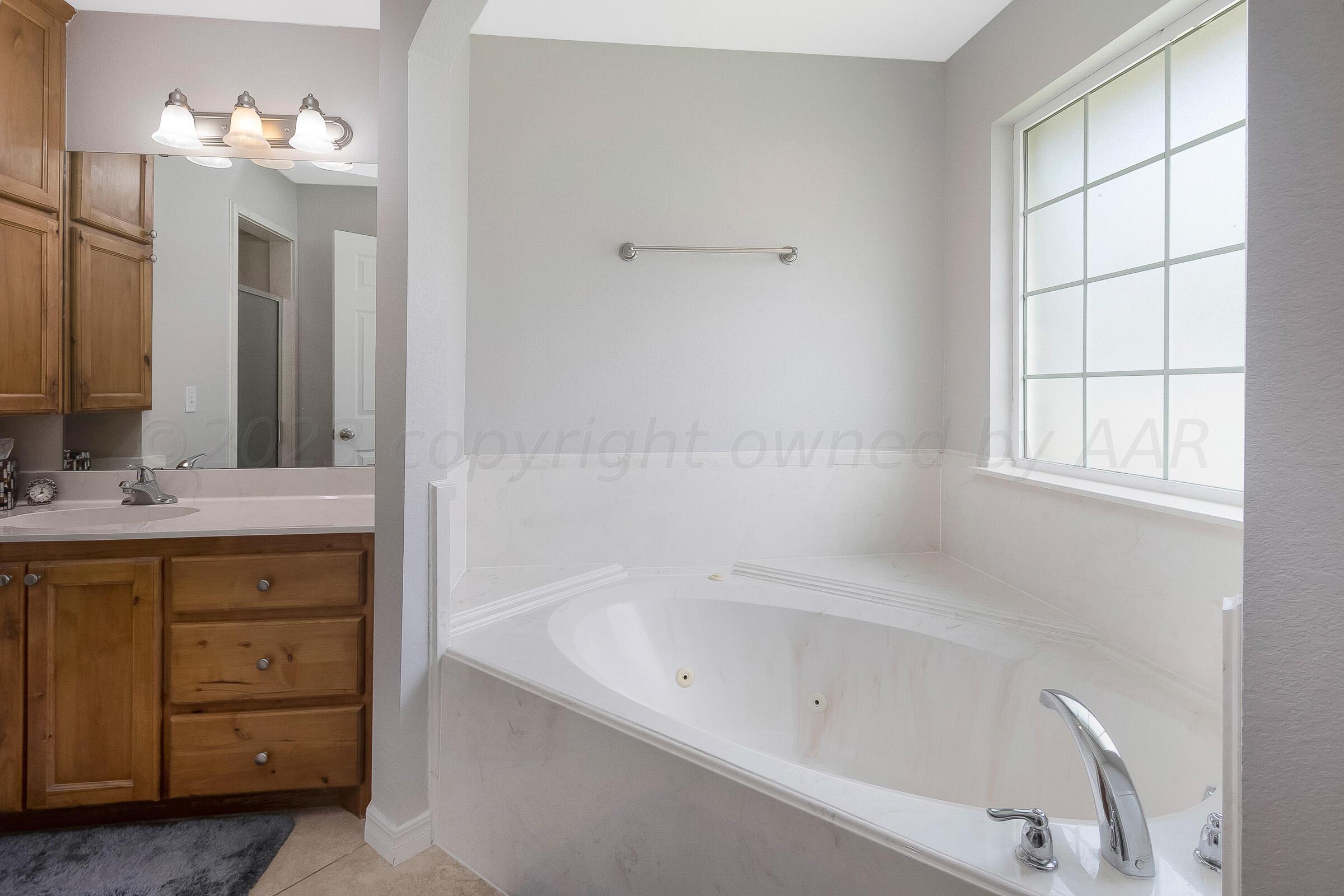 6502 Lexis Street Amarillo, TX 79119 - Photo 15 of 27 a bathroom with a tub sink and mirror