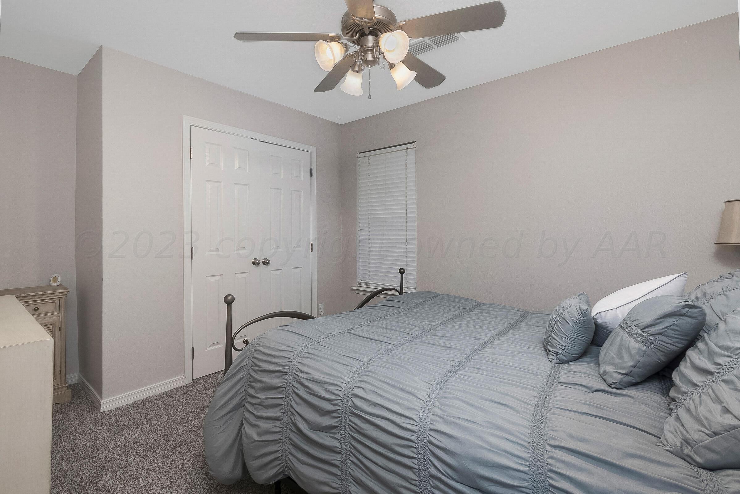 6502 Lexis Street Amarillo, TX 79119 - Photo 16 of 27 a bedroom with a bed and a chandelier