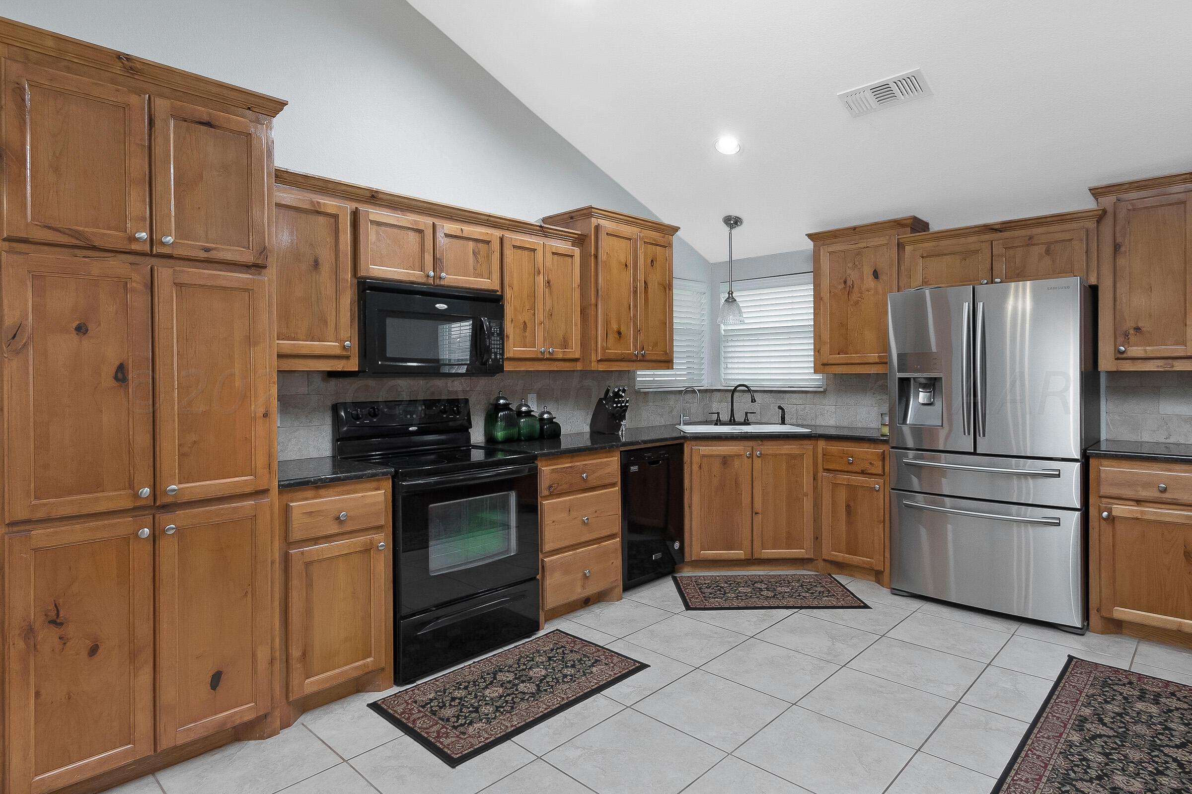 6502 Lexis Street Amarillo, TX 79119 - Photo 8 of 27 a kitchen with a refrigerator stove and microwave