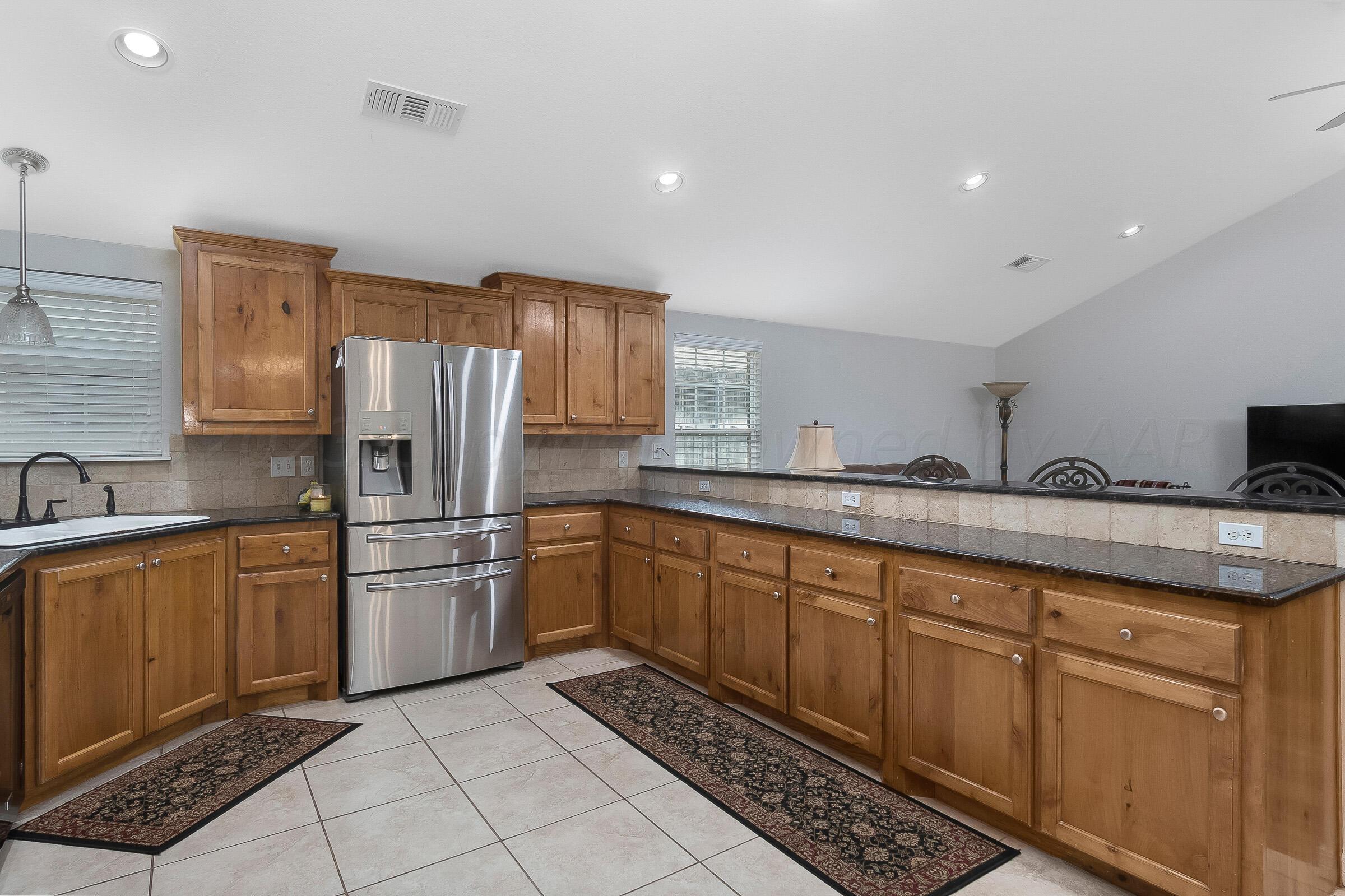 6502 Lexis Street Amarillo, TX 79119 - Photo 9 of 27 a kitchen with stainless steel appliances granite countertop a refrigerator sink and cabinets