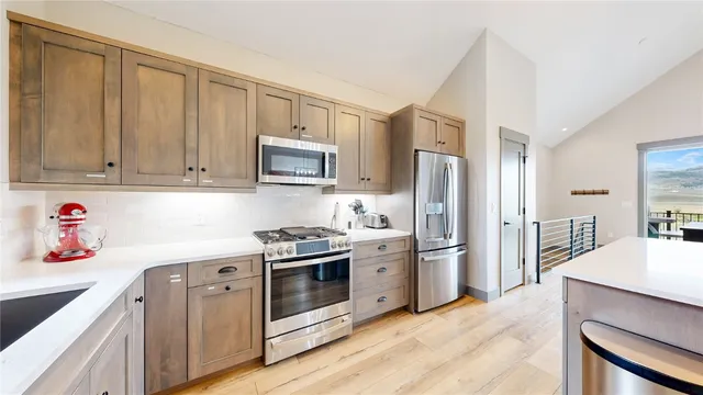 a kitchen with stainless steel appliances granite countertop a refrigerator stove and sink