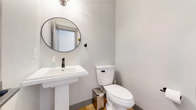 a bathroom with a sink a toilet and a mirror