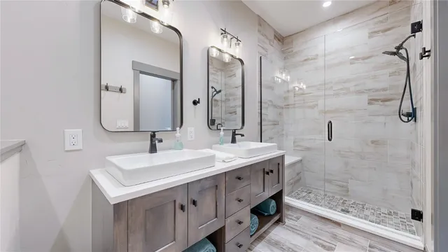 a bathroom with a double vanity sink mirror and shower