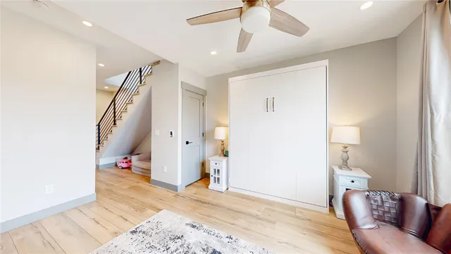 a view of a livingroom with wooden floor and staircase