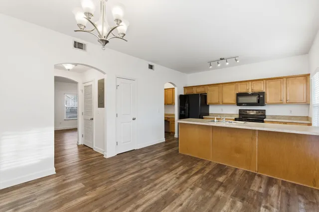 a large white kitchen with stainless steel appliances granite countertop a sink and cabinets