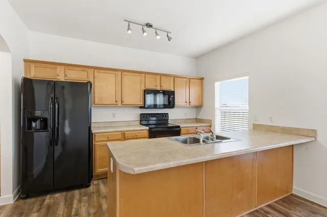 a kitchen with stainless steel appliances granite countertop a sink refrigerator and microwave