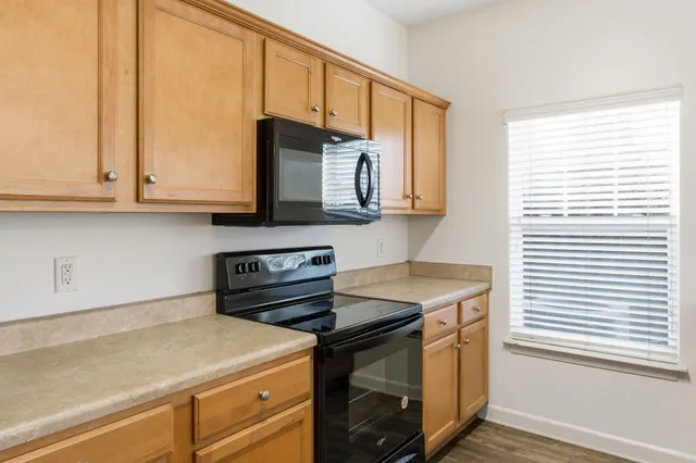 a kitchen with stainless steel appliances white cabinets and a stove top oven