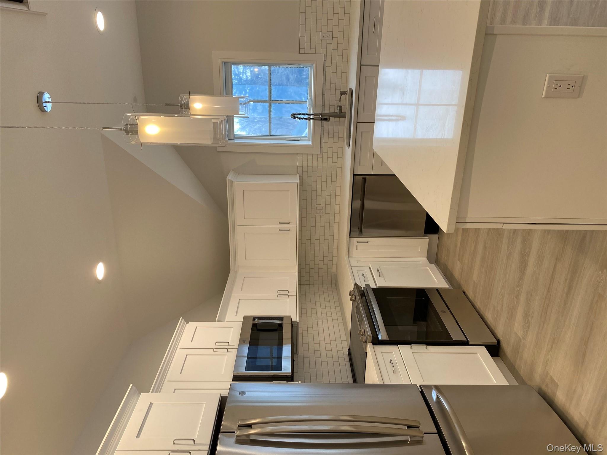 a kitchen with a sink a microwave a stove and refrigerator