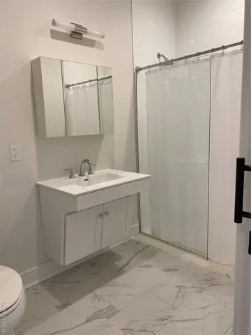 a bathroom with a sink vanity toilet and shower