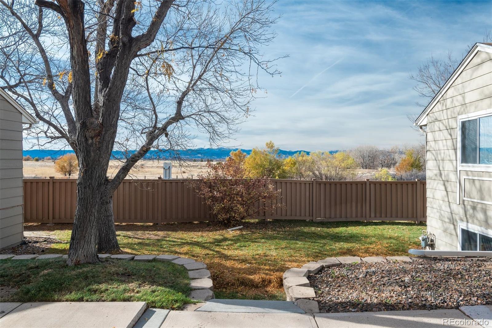 3810 South Atchison Way, Unit F Aurora, CO 80014 - Photo 9 of 39 a view of a yard with a large tree and wooden fence
